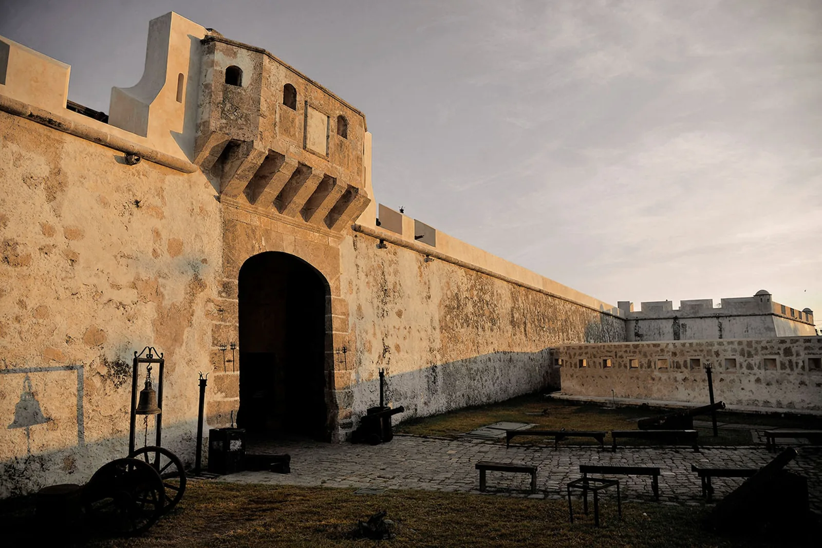 La Puerta de Tierra y la cortina de muralla de Campeche al atardecer, con los cañones en el patio